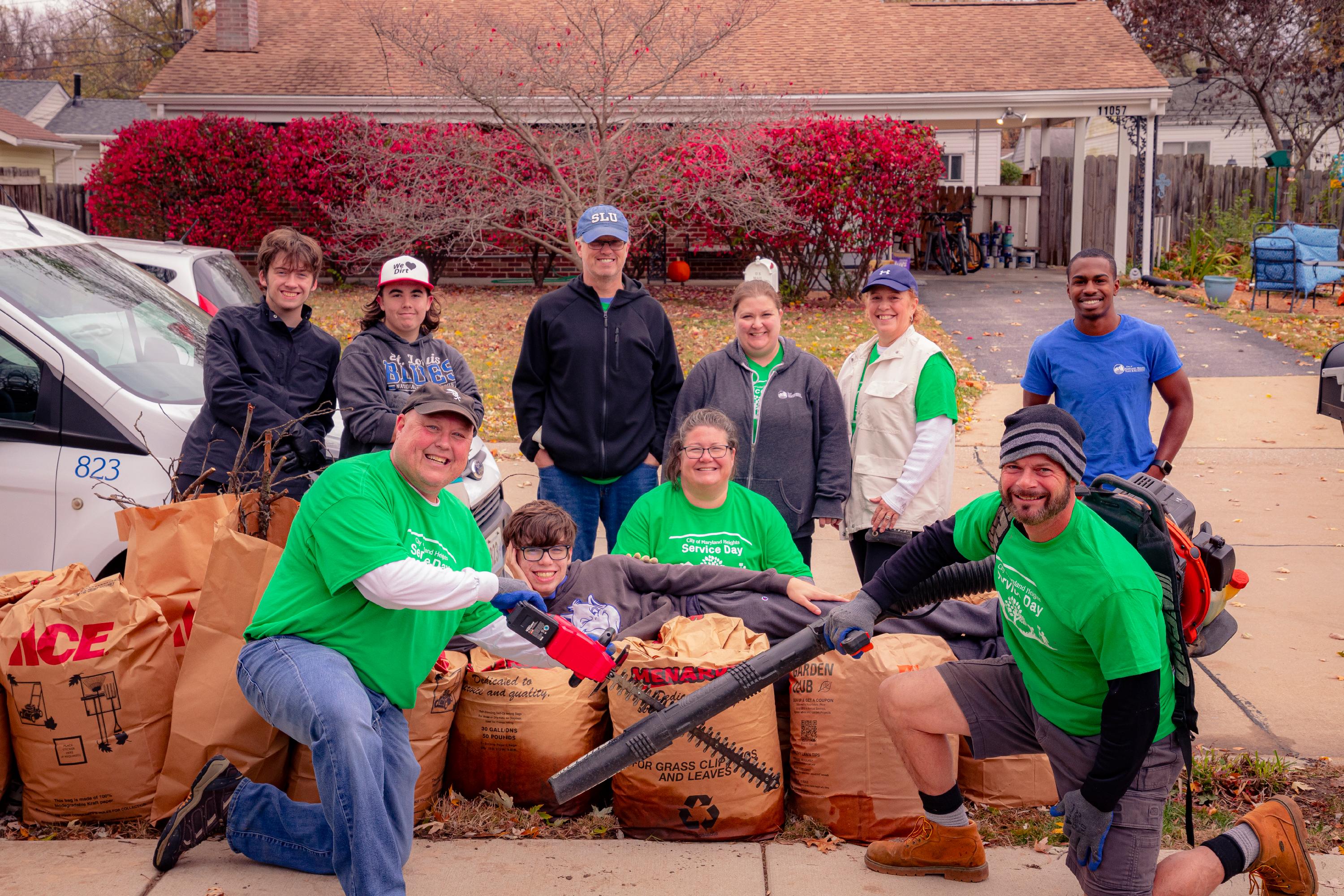 group of volunteers posing with bags filled with leaves